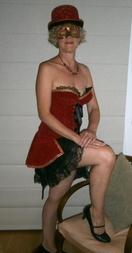 Old blonde woman Jacqueline gets naked in a funky hat and masquerade mask